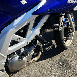 Black SHOGUN frame sliders for motorcycle body protection, shown mounted on a bike with a sleek black finish.