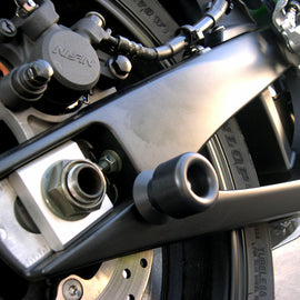 SHOGUN black swingarm sliders for motorcycle body protection, shown attached to bike's swingarm in a sleek black finish.