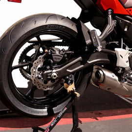 Black SHOGUN swingarm sliders for motorcycle body protection, mounted on a bike with a sleek design.