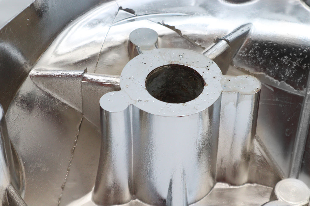 Chrome outer primary cover for drive line from Motorshop, showcasing a shiny, reflective finish with detailed mounting features.