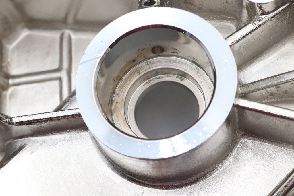 Chrome inner primary cover for motorcycle drive line by Motorshop, showcasing a polished, reflective finish on a black background.