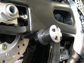 Black SHOGUN swingarm sliders for motorcycle body protection, featuring durable metal construction with mounting brackets.