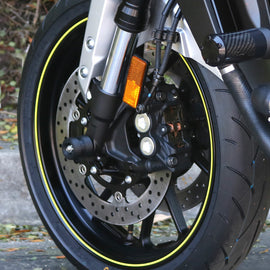Black front axle sliders for motorcycle body protection, branded SHOGUN, shown mounted on a motorcycle.