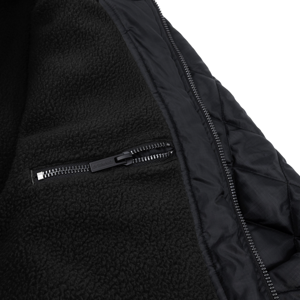Black DBK liner jacket with a sleek design, featuring a zip-up front and lightweight fabric, ideal for layering and casual wear.