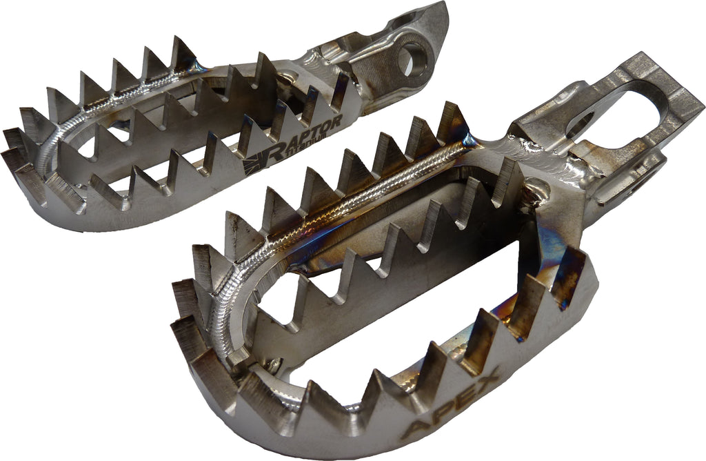 Titanium Beta foot pegs from RAPTOR for motorcycle foot controls, featuring durable metallic construction and a sleek design.