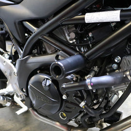 Black Suz Frame Sliders for motorcycle body protection by SHOGUN, shown on a sleek bike.