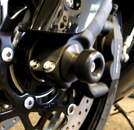 Shogun black front axle sliders for motorcycle body protection, shown mounted on the front axle.