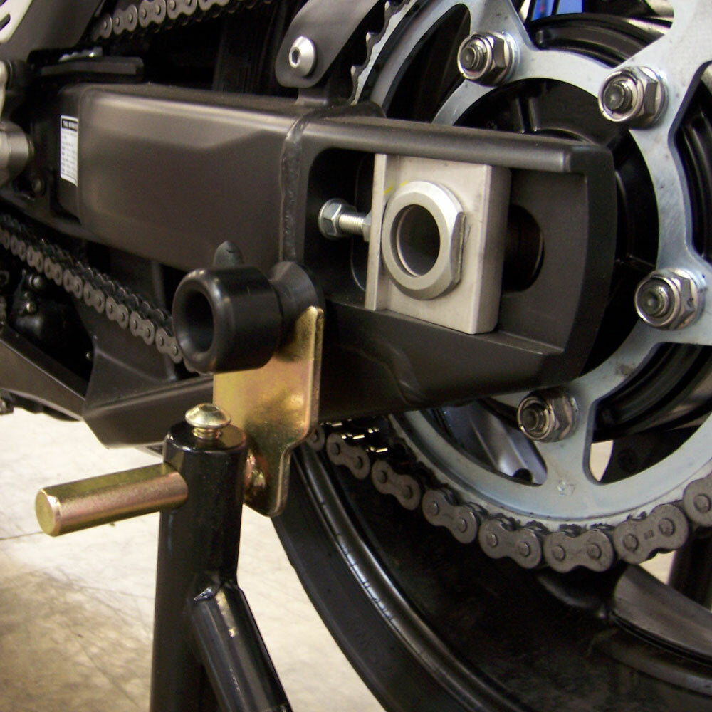 Black Shogun swingarm sliders for motorcycle body protection, shown installed on a bike's swingarm.